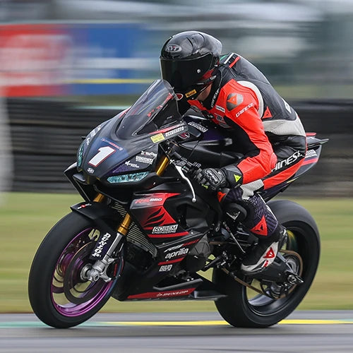Allesandro Di Mario powering out of a corner at a race track in his KYT KX-1 Race GP motorcycle helmet