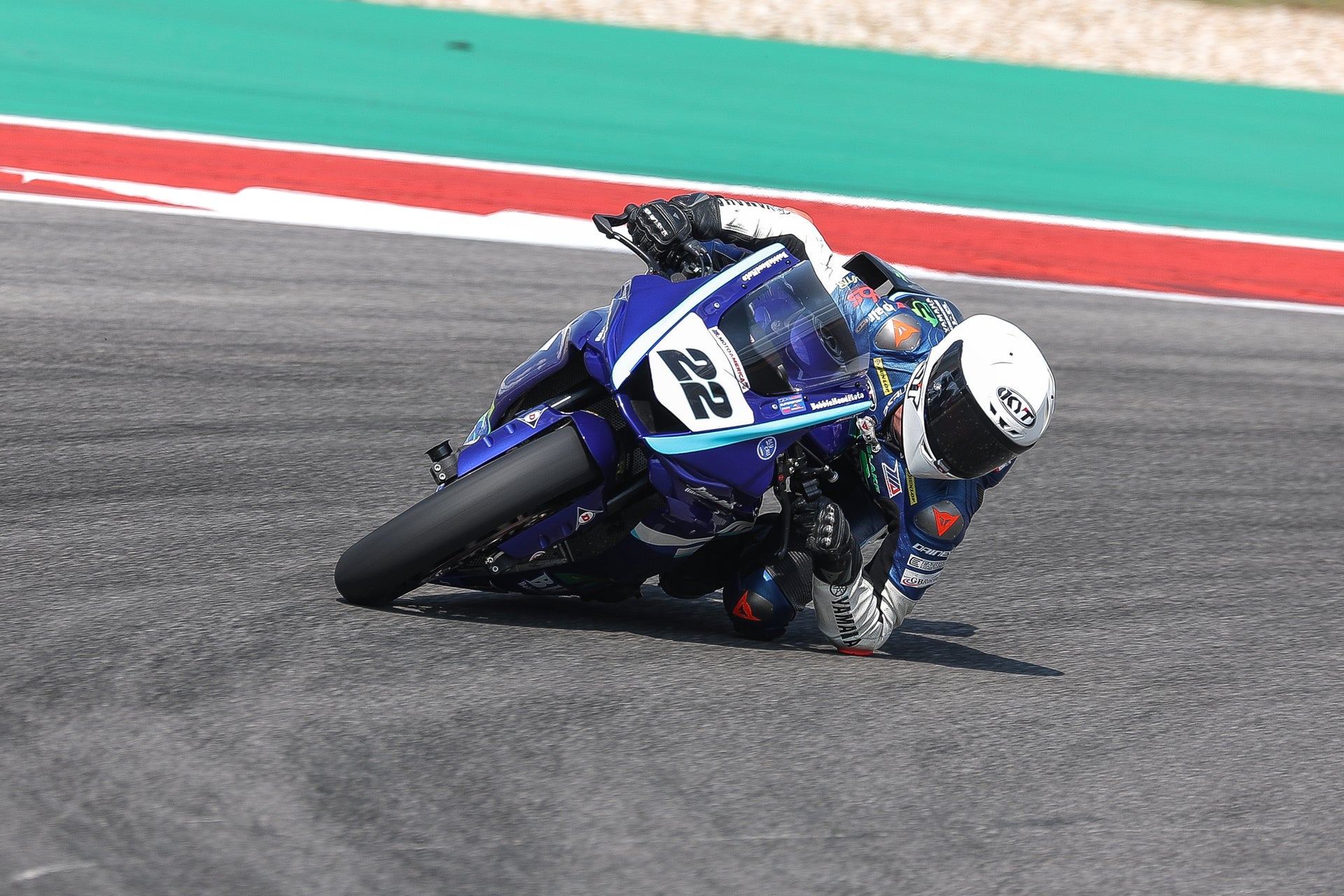 KYT Americas rider, Blake Davis dragging elbow and knee at Circuit of the Americas on his Blue and White Yamaha R7 in a white KX-1 Race GP.