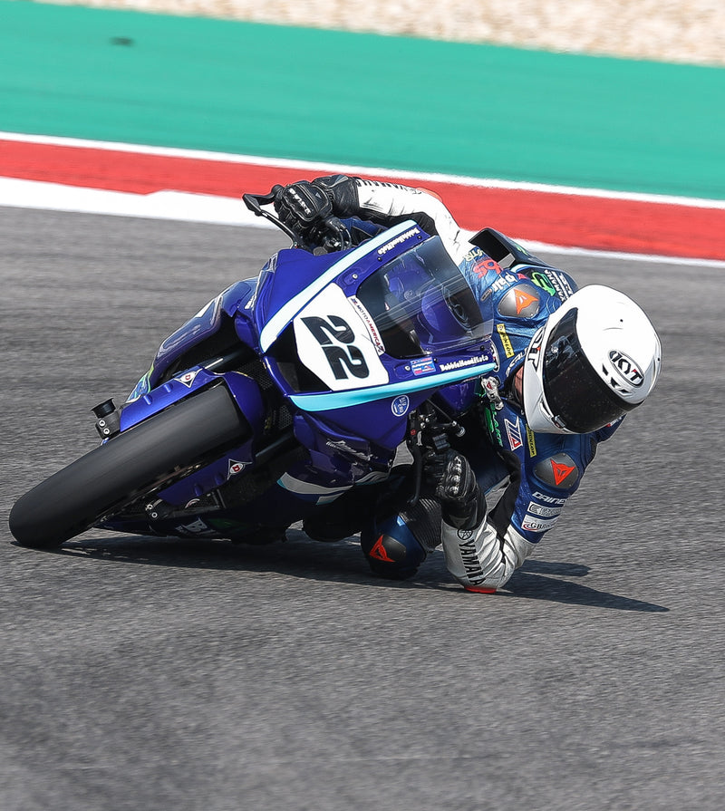 KYT Americas rider, Blake Davis dragging elbow and knee at Circuit of the Americas on his Blue and White Yamaha R7 in a white KX-1 Race GP.