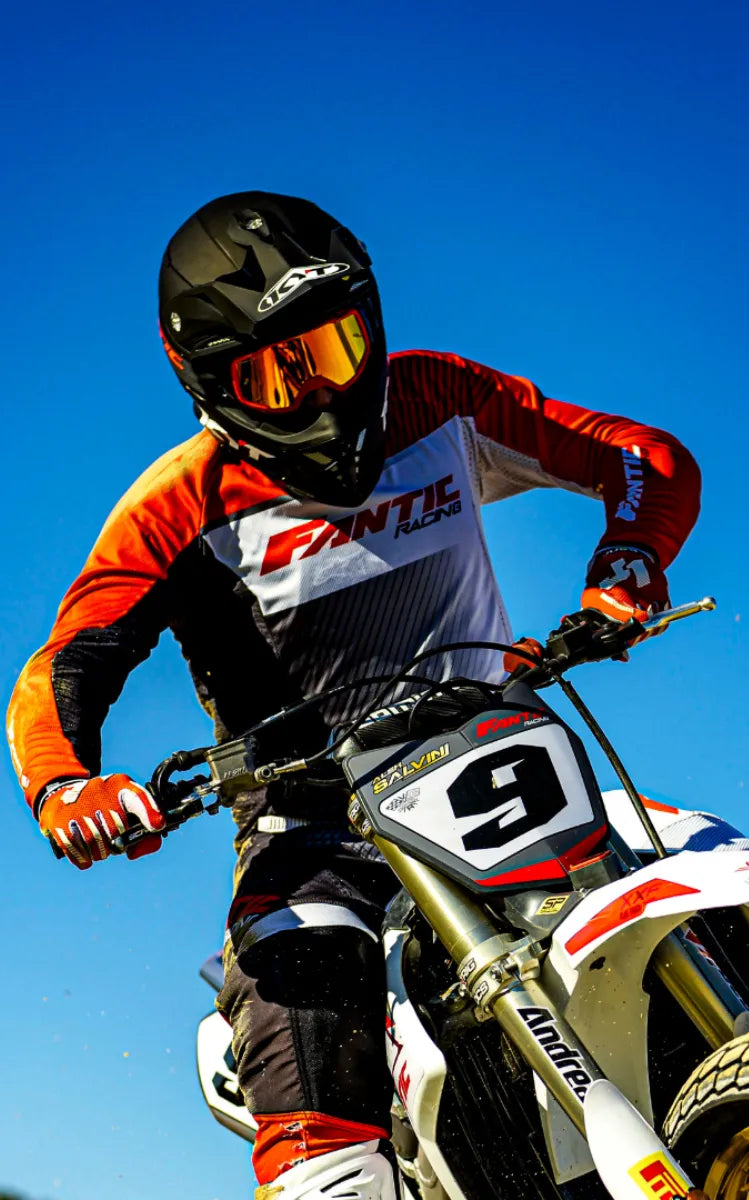 KYT rider, Alex Salvini of Fantic Racing in the air after a jump in a black KYT Skyhawk dirt helmet.